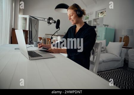 Kaukasische Geschäftsfrau, die von zu Hause aus Podcast aufzeichnet Stockfoto