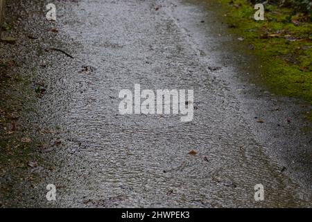 Nach dem Regen fließt Wasser über einen Gehweg Stockfoto