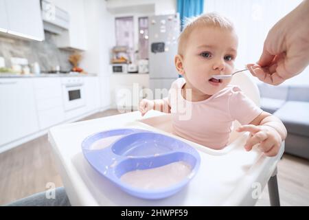 Charmante kleine Mädchen in rosa Kleidung am Morgen Frühstück zu Hause Stockfoto