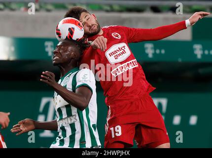 BUDAPEST, UNGARN - 6. MÄRZ: Fortune Bassey von Ferencvarosi TC kämpft während des ungarischen OTP Bank Liga Spiels zwischen Ferencvarosi TC und Kisvarda Master Good am 6. März 2022 in der Groupama Arena in Budapest, Ungarn, um den Ball in der Luft mit Herdi Prenga von Kisvarda Master Good. Stockfoto