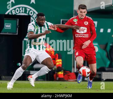 BUDAPEST, UNGARN - 6. MÄRZ: Anderson Esiti von Ferencvarosi TC fordert Bence Otvos von Kisvarda Master Good während des ungarischen OTP Bank Liga-Spiels zwischen Ferencvarosi TC und Kisvarda Master Good am 6. März 2022 in der Groupama Arena in Budapest, Ungarn, heraus. Stockfoto