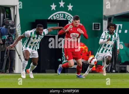 BUDAPEST, UNGARN - 6. MÄRZ: Anderson Esiti von Ferencvarosi TC fordert Bence Otvos von Kisvarda Master Good neben Tokmac Chol Nguen von Ferencvarosi TC (r) während des ungarischen OTP Bank Liga-Spiels zwischen Ferencvarosi TC und Kisvarda Master Good am 6. März 2022 in der Groupama Arena in Budapest, Ungarn, heraus. Stockfoto