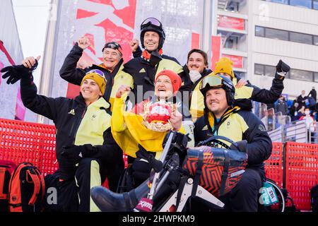 Peking, China. 07. März 2022. Paralympics, para Alpine Skiing, Frauen, kombiniert, sitzen, Im Nationalen Alpinen Skizentrum: Anna-Lena Forster aus Deutschland (M) freut sich über ihren ersten Platz mit Leander Kress (l) aus Deutschland Justus Wolf (r), Nationaltrainer, und anderen Teammitgliedern. Quelle: Christoph Soeder/dpa/Alamy Live News Stockfoto