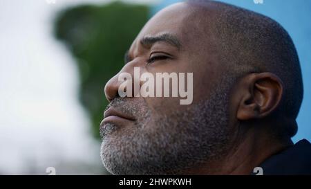 Ein nachdenklicher schwarzer afrikanischer älterer Mann schließt die Augen Stockfoto