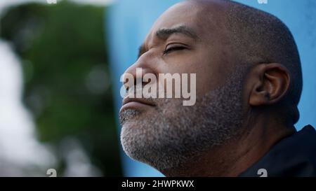 Ein nachdenklicher schwarzer afrikanischer älterer Mann schließt die Augen Stockfoto