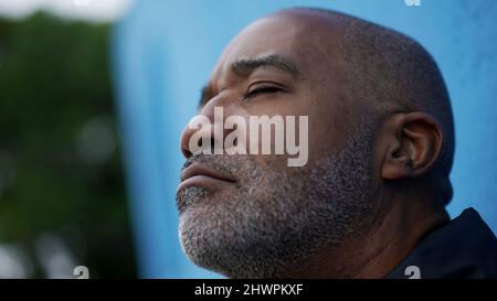 Ein nachdenklicher schwarzer afrikanischer älterer Mann schließt die Augen Stockfoto