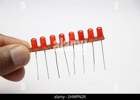 Elektronische Leiterplatte mit roter Diode, die parallel geschaltet ist. Gruppe von roten Leuchtdioden in der Hand gehalten Stockfoto