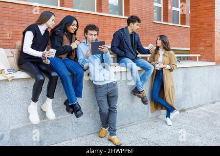 Junge Freunde sprechen vor der Uni Stockfoto