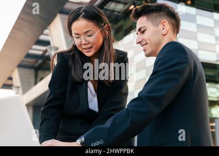 Multirassische Geschäftskollegen, die am Laptop zusammenarbeiten Stockfoto