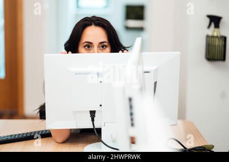 Geschäftsfrau sitzt hinter dem Computer am Schreibtisch im Coworking-Büro Stockfoto