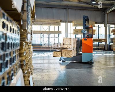 Lagerarbeiter, der Gabelstapler in Industriegebäude betreibt Stockfoto
