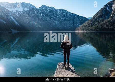Frau mit Blick über den Plansee zu den Ammergauer Alpen, Reutte, Tirol, Österreich Stockfoto
