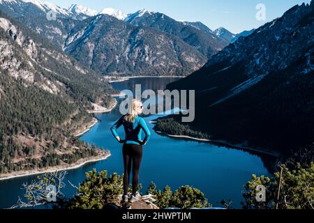 Frau mit Händen an der Hüfte, Blick von Tauern über den Plansee, die Ammergauer Alpen, Reutte, Tirol, Österreich Stockfoto
