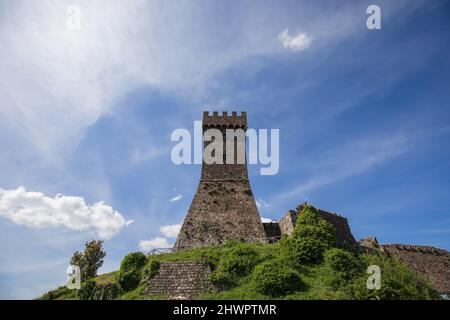 Backsteinturm Rocca von Radocofani mit dem bewölkten Himmel Hintergrund an einem Sommertag, Toskana, Italien (Val d'Orcia) Stockfoto