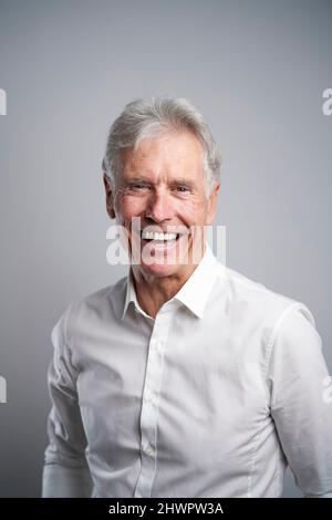 Leitender Geschäftsmann, der im Studio lacht Stockfoto