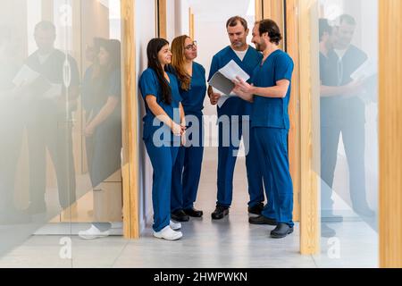 Ärzte und Krankenschwestern diskutieren gemeinsam auf dem Flur im Krankenhaus Stockfoto
