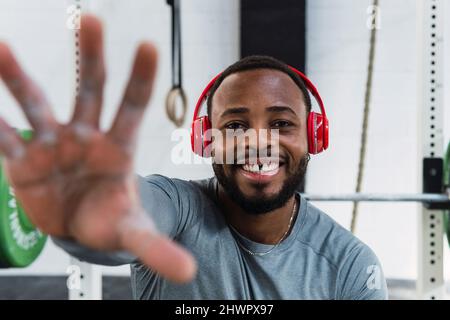 Sportler mit Zahnlücke gestikuliert im Fitnessstudio Stockfoto