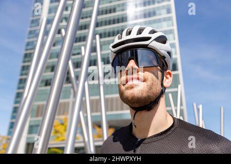 Junger Radfahrer mit Sonnenbrille und Helm Stockfoto