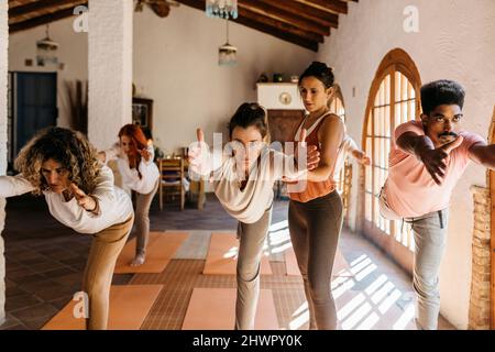 Yogalehrer, der Schüler in der Klasse unterstützt Stockfoto