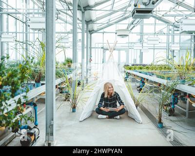 Biologe mit Tablet-PC im Zelt im Kinderzimmer Stockfoto