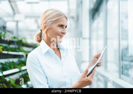 Wissenschaftler mit Tablet-PC im städtischen Garten Stockfoto