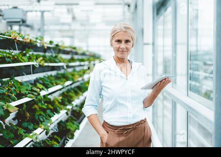 Biologe mit Tablet-PC im Gewächshaus-Labor Stockfoto