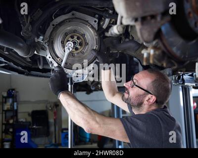 Mechaniker Reparatur Autorad in Auto-Werkstatt Stockfoto