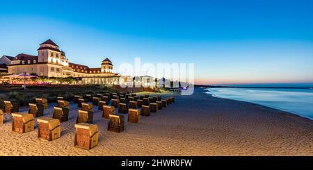 Deutschland, Mecklenburg-Vorpommern, Binz, am Strand vor dem Kurhaus Binz in der Abenddämmerung stehende Liegen mit Kapuze Stockfoto