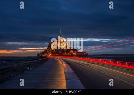 Frankreich, die Normandie, Lichterwege entlang der Brücke, die die Insel Mont-Saint-Michel in der Abenddämmerung verbindet Stockfoto