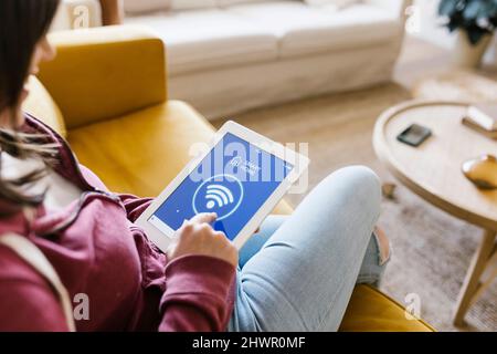 Junge Frau steuert Smart Home über einen Tablet-PC Stockfoto