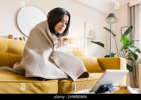Junge Frau auf Videoanruf mit Arzt zu Hause Stockfoto