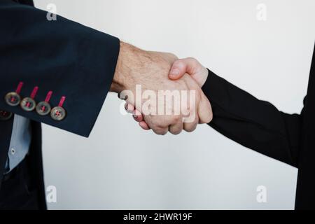 Geschäftsmann und Geschäftsfrau beim Händeschütteln im Büro Stockfoto