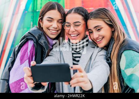 Glückliche Freunde, die Selfie über das Mobiltelefon machen Stockfoto