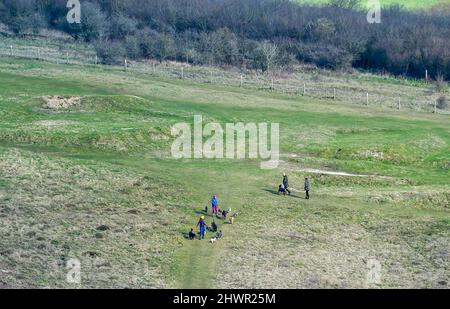 Brighton UK 7. March 2022 - Hundewanderer genießen einen sonnigen, aber kühlen Morgen auf den South Downs auf dem alten Golfplatz Waterhall, der nördlich von Brighton aufgehalten wurde : Credit Simon Dack / Alamy Live News Stockfoto