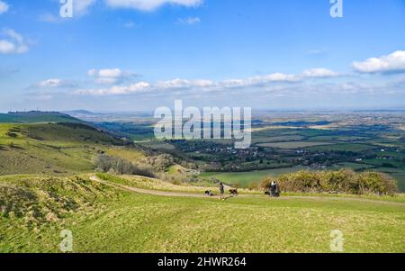 Brighton UK 7. March 2022 - Hundewanderer genießen einen sonnigen, aber kühlen Morgen auf den South Downs am Devils Dyke nördlich von Brighton : Credit Simon Dack / Alamy Live News Stockfoto