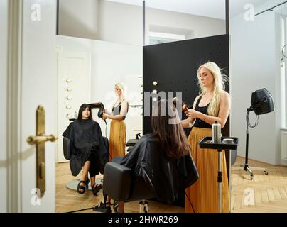 Friseur styling Kunden Haar im Salon Stockfoto