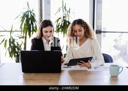 Multiethnische Geschäftskollegen, die im Coworking Office mit drahtlosen Technologien arbeiten Stockfoto