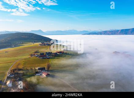 Drohnenansicht des Bergdorfes und des Tales, umgeben von dichtem Morgennebel Stockfoto
