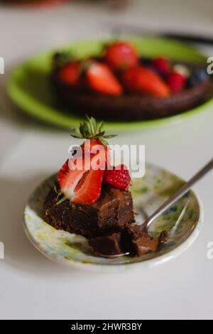 Tortenscheibe mit Erdbeeren in Teller auf dem Tisch Stockfoto