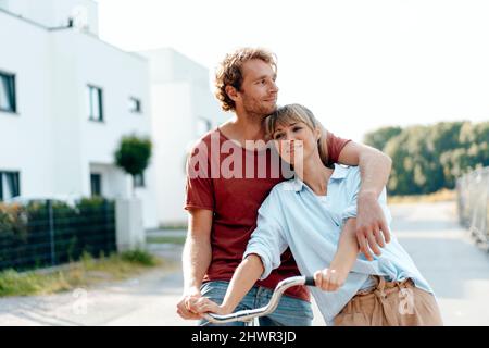 Nachdenklicher Mann und Frau mit Fahrrad auf dem Fußweg Stockfoto