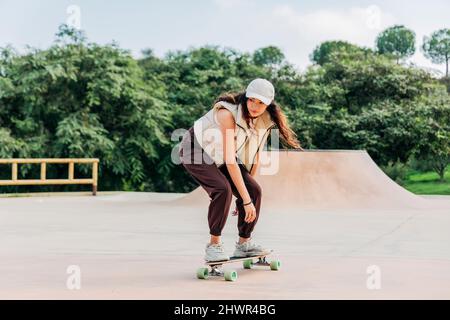 Junge Frau Skateboarding auf Sportrampe Stockfoto