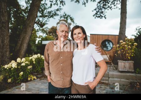 Lächelndes Paar, das zusammen im Hinterhof steht Stockfoto