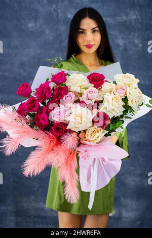 Ein großer Strauß Rosen und andere Blumen von einem schönen Mädchen gehalten Stockfoto