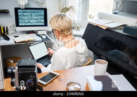 Blonde Frau mit Tablet-PC im Büro Stockfoto