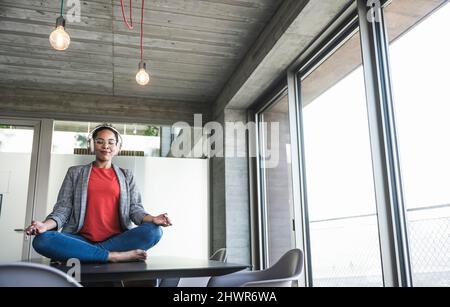 Geschäftsfrau, die am Arbeitsplatz Yoga macht Stockfoto