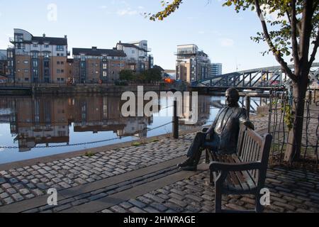 Blick auf Leith, Edinburgh, Schottland, inklusive einer Statue von Sandy Irvine Robertson OBE, die auf einer Bank am Wasser saß Stockfoto