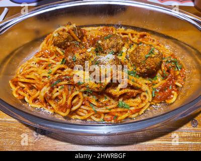 Teller mit Spaghetti mit Fleischbällchen auf einem Holztisch. Stockfoto