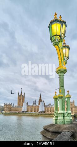 Farbenfrohe achteckige viktorianische Lampen an der Westminster-Brücke neben den Houses of Parliament leuchten an einem langweiligen Wintertag. Stockfoto