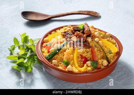 Fleisch- und Gemüsesorten Couscous, traditionelle marokkanische Küche, mit frischem Koriander und Minze. Festliches arabisches Gericht Stockfoto
