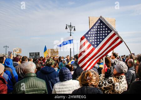 Bewohner von Brighton Beach treffen sich am 6. März 2022 zu einer Pro-Ukraine-Kundgebung auf dem Riegelmann Boardwalk und Brighton 6. in Brooklyn, New York, NY. Viele tragen die gelben und blauen Farben der ukrainischen Flagge, um ihre Unterstützung zu zeigen. Die größten ukrainisch-amerikanischen Gemeinden in New York City befinden sich in den Gebieten Brighton Beach und Sheepshead Bay in Brooklyn. Brighton Beach wurde aufgrund seiner Bevölkerung von Einwanderern aus der Ukraine, Russland und anderen ehemaligen sowjetischen Gebieten den Spitznamen Little Odessa erhalten. Russlands Angriff auf die Ukraine hat zu vielen Kundgebungen zur Unterstützung der Ukraine auf der ganzen Welt geführt. (Foto von Erica PR Stockfoto